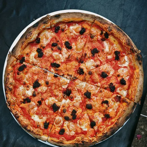 burnt. ’nduja pizza on sourdough with tomato and mozzarella, top view