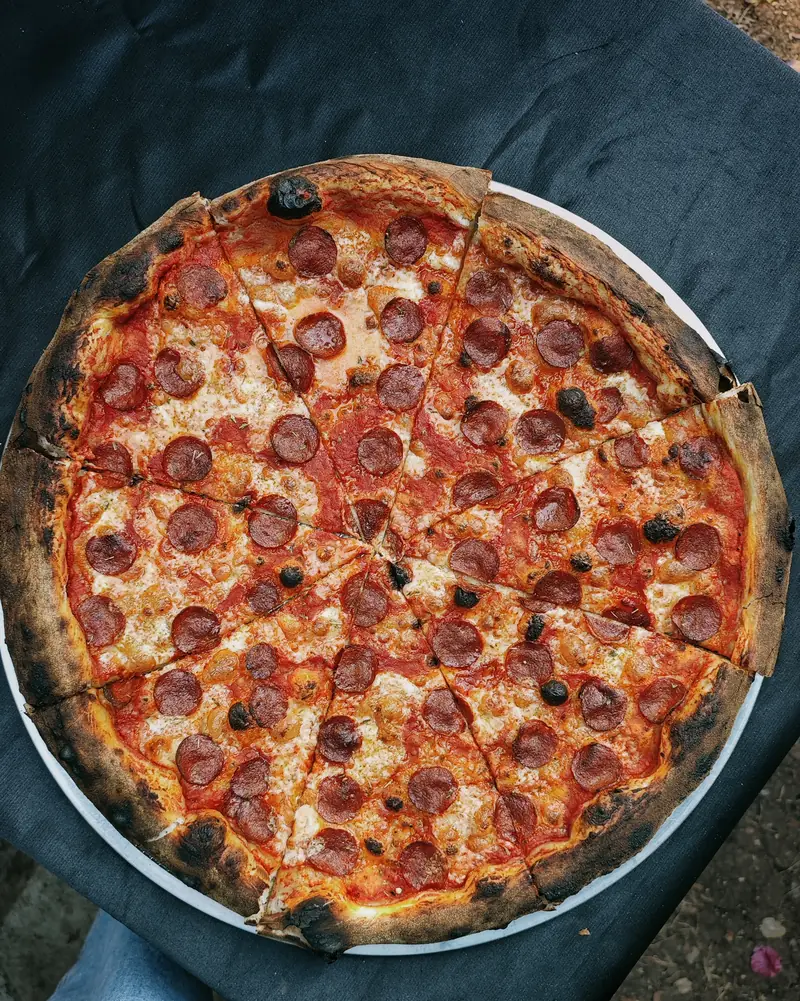 burnt. new york style sourdough pepperoni pizza, sliced, top view
